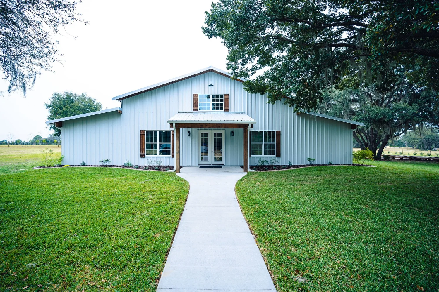 The barn's front porch and white path seen straight on across green lawn